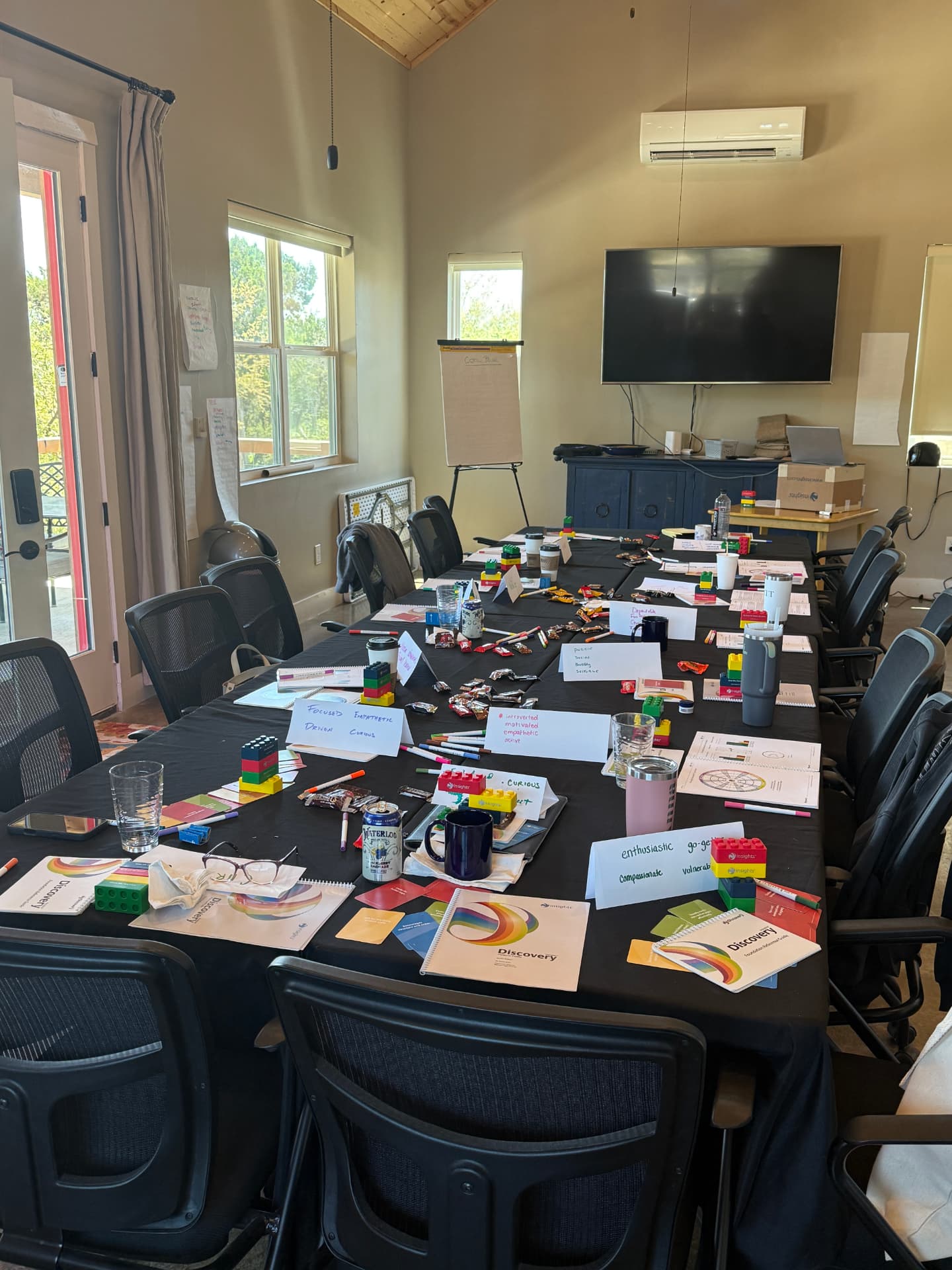 A workshop table set with Insights Discovery workbooks, cards, and building blocks
